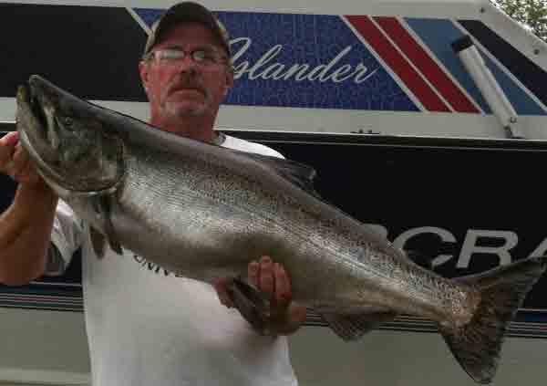 Catches like this king salmon caught by Kevin Claire are going to become less frequent as Lake Michigan fish managers are cutting back on chinook salmon stockings.